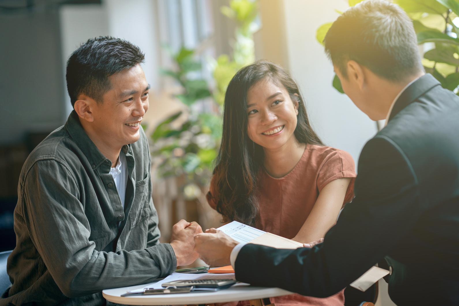 Young asian couple and agent disucss financial planning